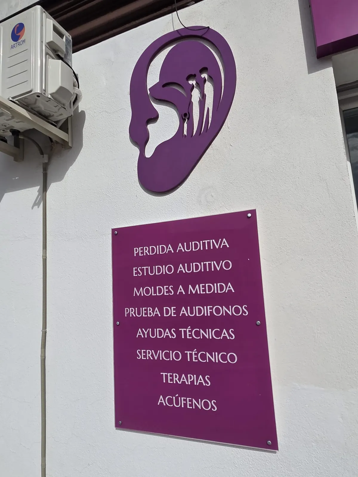 The centre’s logo and a sign listing its services: hearing loss, hearing assessment, custom earmoulds, hearing aid trial, assistive devices, repairs, therapies and tinnitus